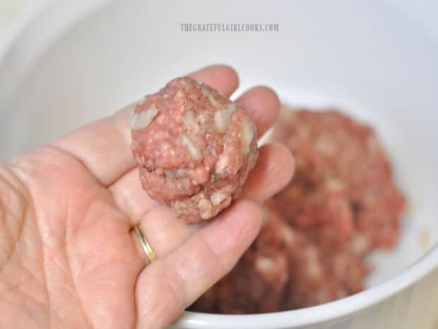 Meat mixture is shaped into meatballs, ready to be cooked.