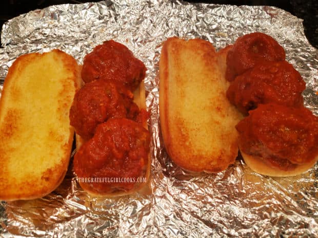 Each toasted hoagie roll is topped with 3 hot meatballs and marinara sauce.