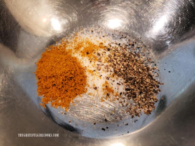 Spice mix is made by combining salt, pepper, curry powder, and onion powder in a small bowl.