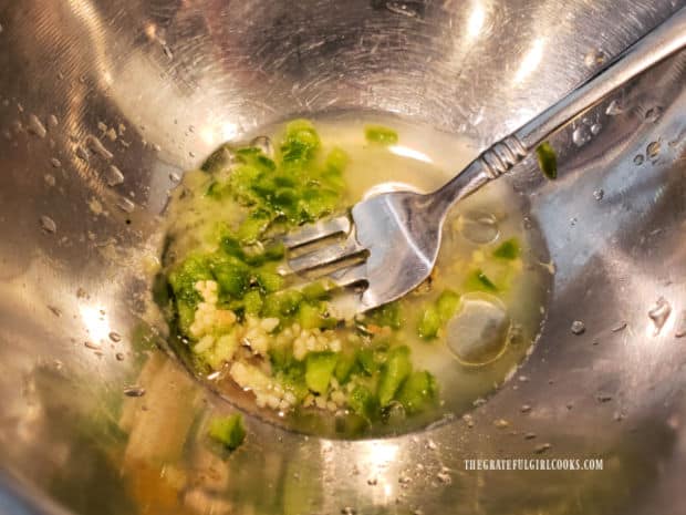 A fork is used to whisk together the ingredients for the simple salad dressing.