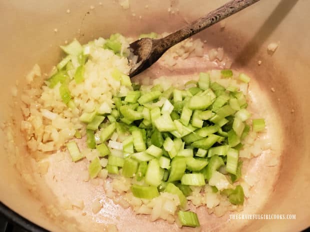 Celery is added to the onions and garlic in the pan.