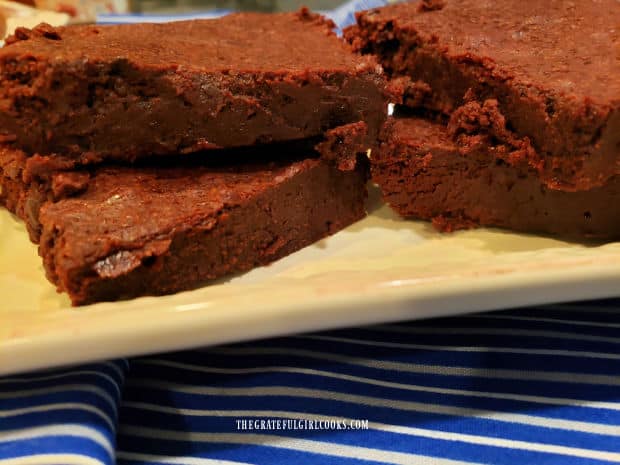 A beige platter with four mocha cinnamon brownies on it, ready to be eaten.