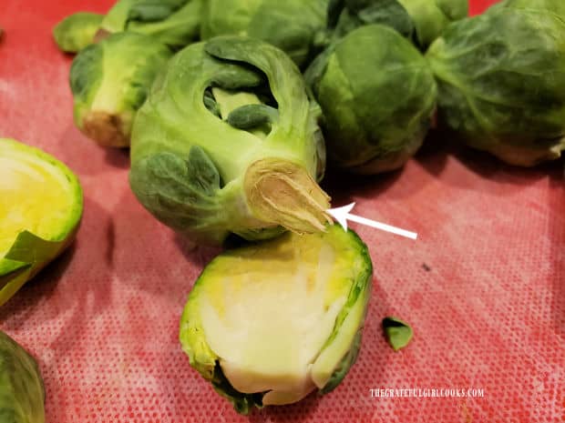 The stems are trimmed off of the Brussel sprouts before seasoning and slicing.