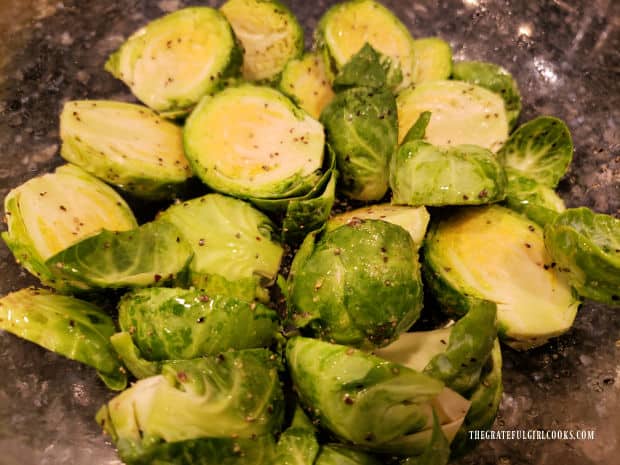 Seasonings are added to the oil-tossed Brussel sprouts before baking.