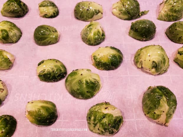 Seasoned Brussel sprout halves are roasted, cut side down on parchment lined baking sheet.