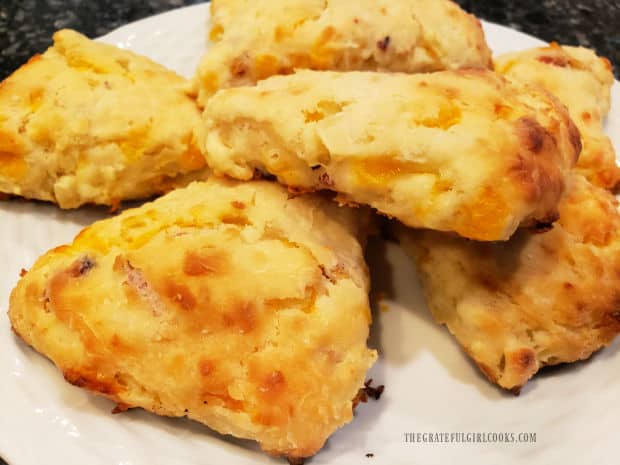 Bacon apple cheddar scones, served on a white plate.