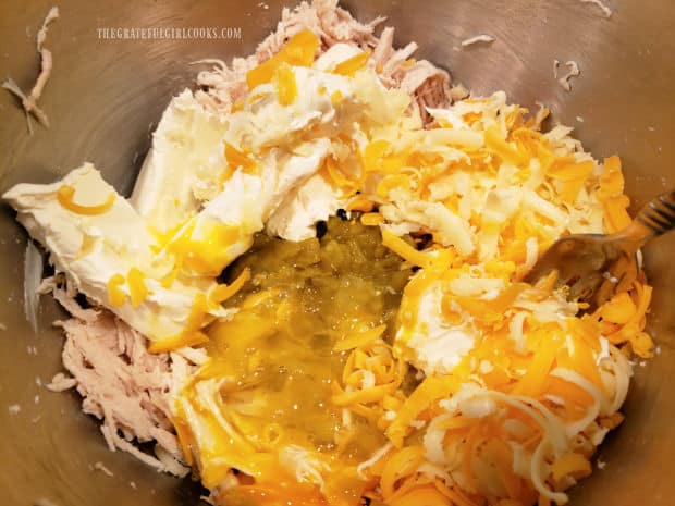 Chicken, cream cheese, green chiles, jack and cheddar cheeses in a bowl.