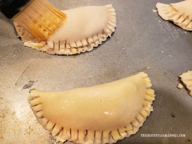 Each hand pie is brushed with beaten egg before baking.