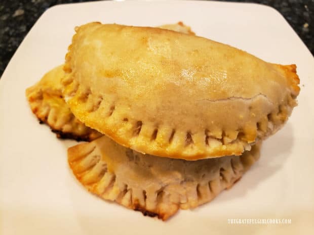 White plate holding a few of the chicken suizas hand pies stacked on top.