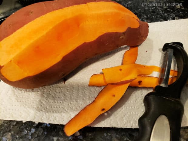 The outer peel is removed from a medium to large sweet potato before slicing.