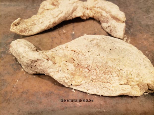 Flour-coated fish fillets rest on baking sheet before battering.
