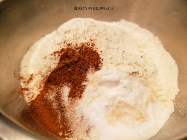 Flour, cinnamon, baking soda and salt are measured into a large bowl.