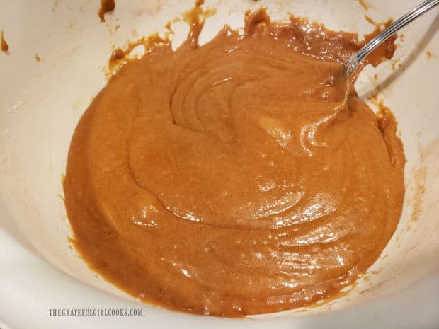 A white bowl, full of combined batter for the carrot cinnamon nut bread.