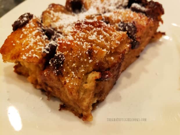 A piece of chocolate chip orange French toast, dusted with powdered sugar.