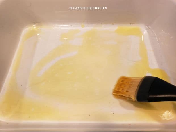 Melted butter is brushed on bottom and sides of a baking dish.