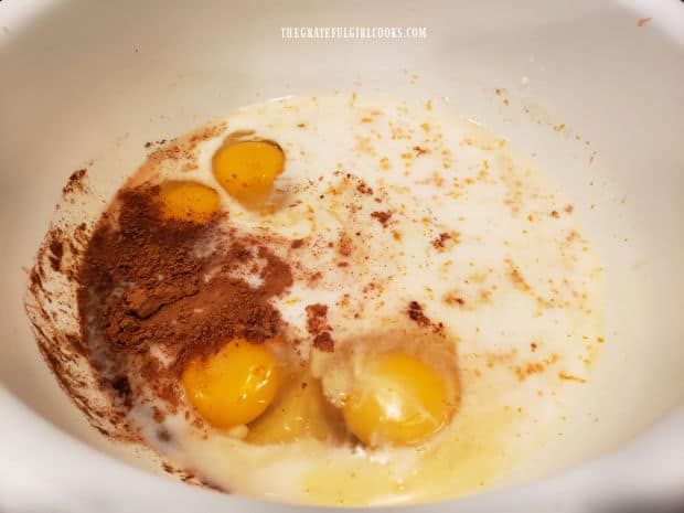 Eggs, milk, OJ, cinnamon, brown sugar, etc. in a large white mixing bowl.