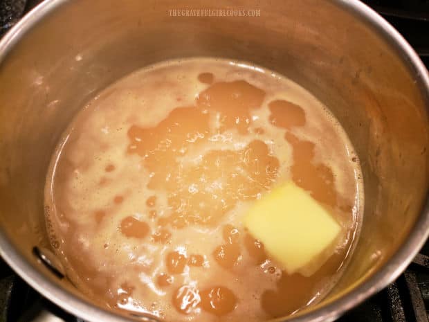 Chicken broth is heated with butter until the butter melts.