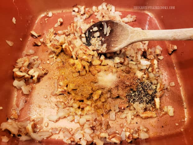 Curry powder, ground ginger, salt and pepper are added to the onion and pecan mixture.