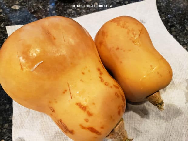 Butternut squash is pierced with a knife before microwaving.