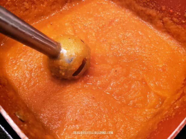 Once pureed, creamy butternut squash bisque is heated through before serving.