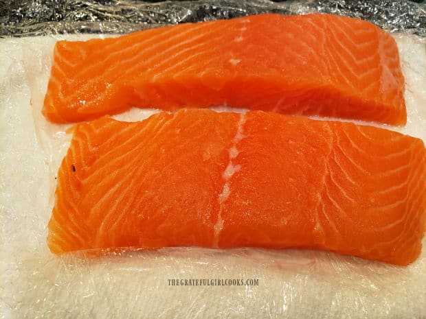 Salmon fillets are patted dry with paper towels to absorb moisture.