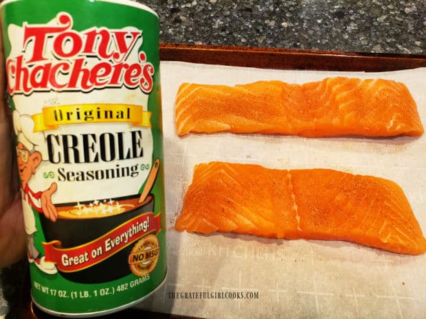 The salmon fillets are sprinkled lightly on top with Creole seasoning mix.