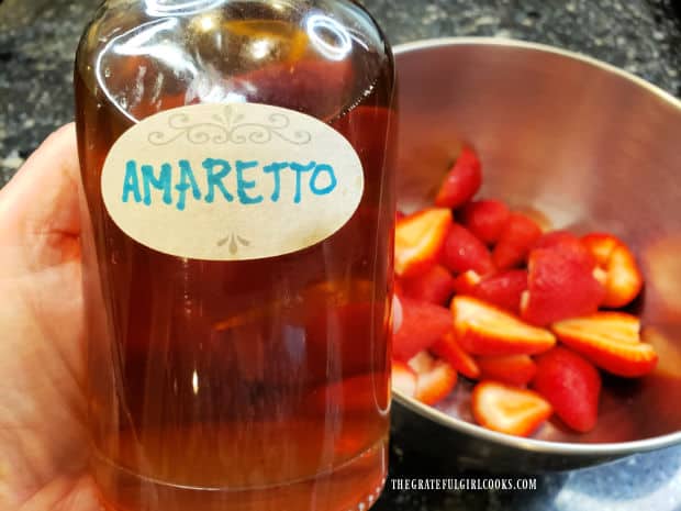 Amaretto liqueur will be added to the bowl of strawberries.