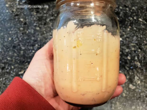 A glass canning jar is filled with thousand island salad dressing, then refrigerated.