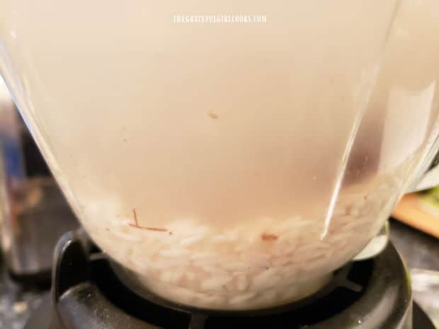 Soaked rice in blender with cinnamon stick pieces and soaking water.