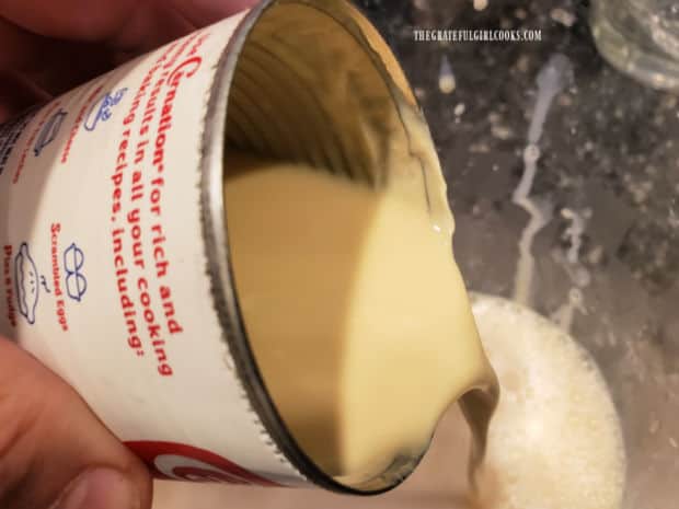 Evaporated and condensed milk are added to the horchata in the pitcher.