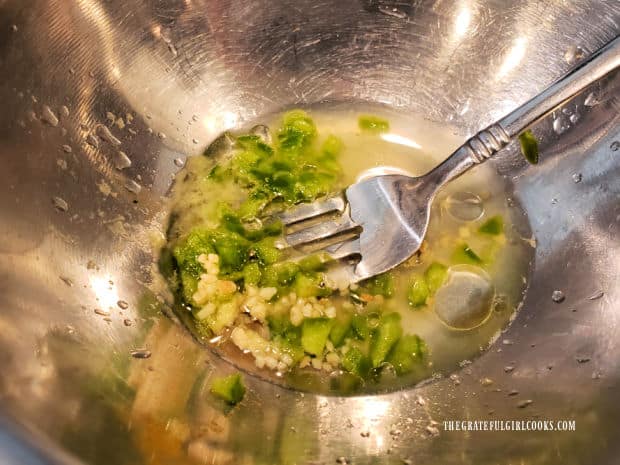Salad dressing ingredients are stirred together until fully combined.