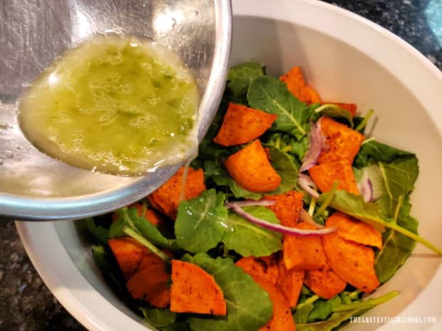 Lime Jalapeño Salad Dressing is poured over a kale salad with sweet potatoes.
