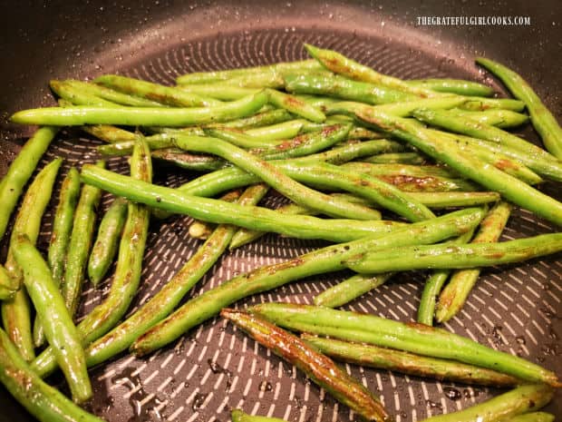 As they cook, the green beans will blister and brown on the outside.