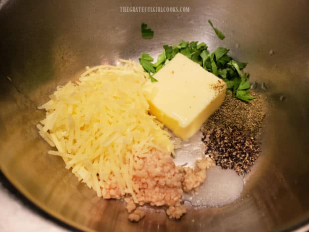 Soft butter, parsley, parmesan, garlic and spices are placed in a small bowl.