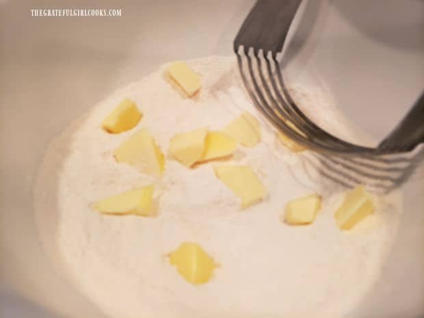 A pastry blender is shown cutting the butter into the flour mixture.