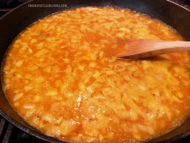 Spiced yellow rice is brought to a boil in the skillet.