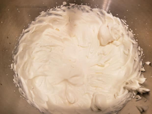 Almond flavored whipping cream is beaten until peaks form.