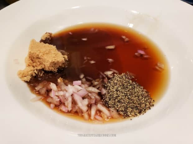 Fish sauce, shallots, brown sugar rice vinegar and pepper, placed in a white bowl.