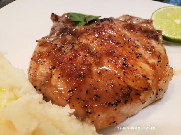 One of the Vietnamese Skillet Pork Chops on a plate, with potatoes and lime wedge.