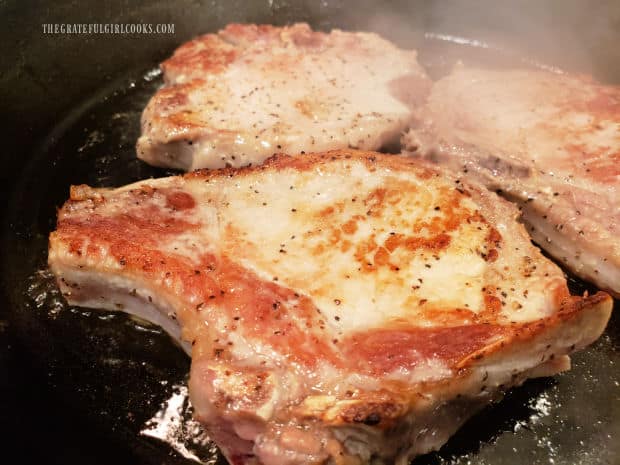 The pork chops are browned on both sides until fully cooked through.