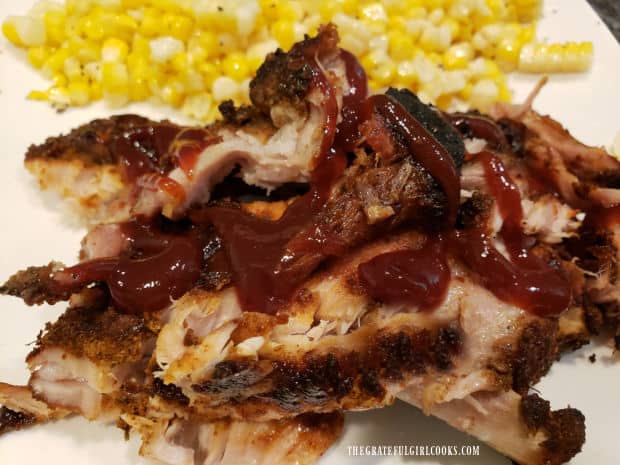 BBQ sauce on the baby back ribs, with fresh corn kernels on the side.