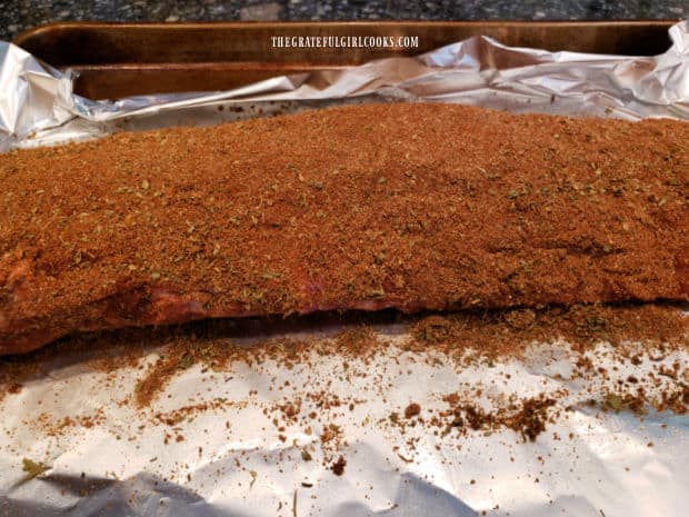 The meaty side of the rib rack is covered fully with dry rub seasonings.