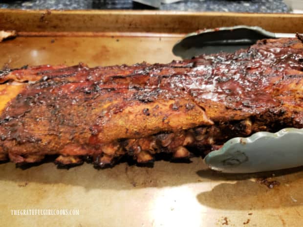 The baked grilled baby back ribs are done, and ready to be cut for serving.