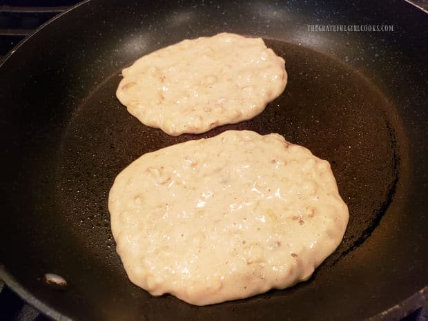 Pancake batter for two pancakes is measured into a hot skillet.