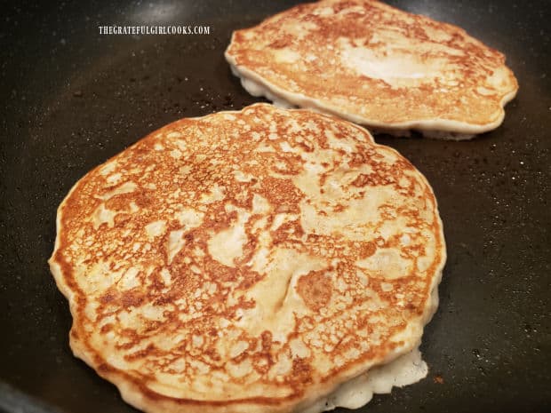 The banana oat pancakes continue to cook on the second side, in skillet.