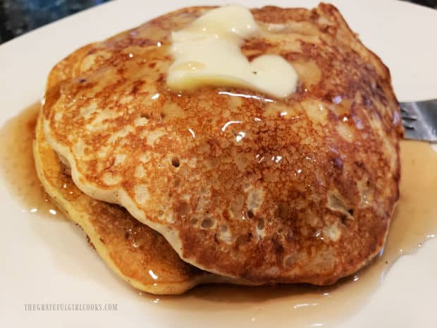 Banana Oat Pancakes, served on a white plate with butter and syrup.