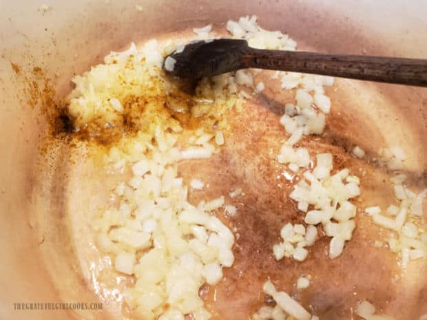 Minced garlic and curry powder are stirred into the cooked onions.