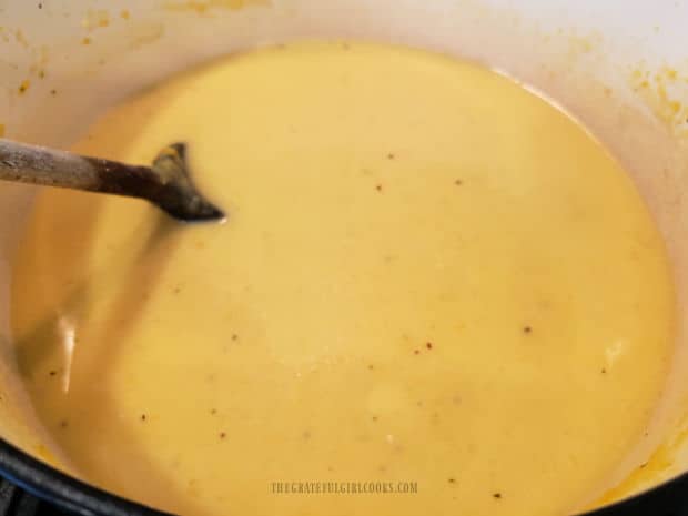 The soup pot with creamy pumpkin coconut soup heating in it.