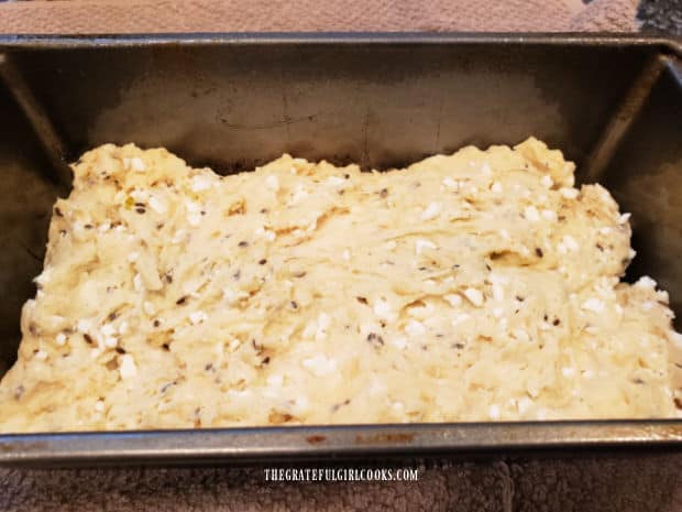 A bread loaf pan is filled with the dough for the dilly bread.