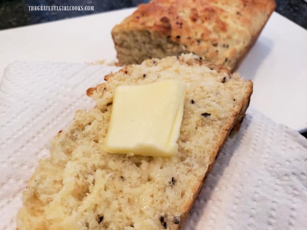 One slice of dilly bread with butter, and the loaf behind it.